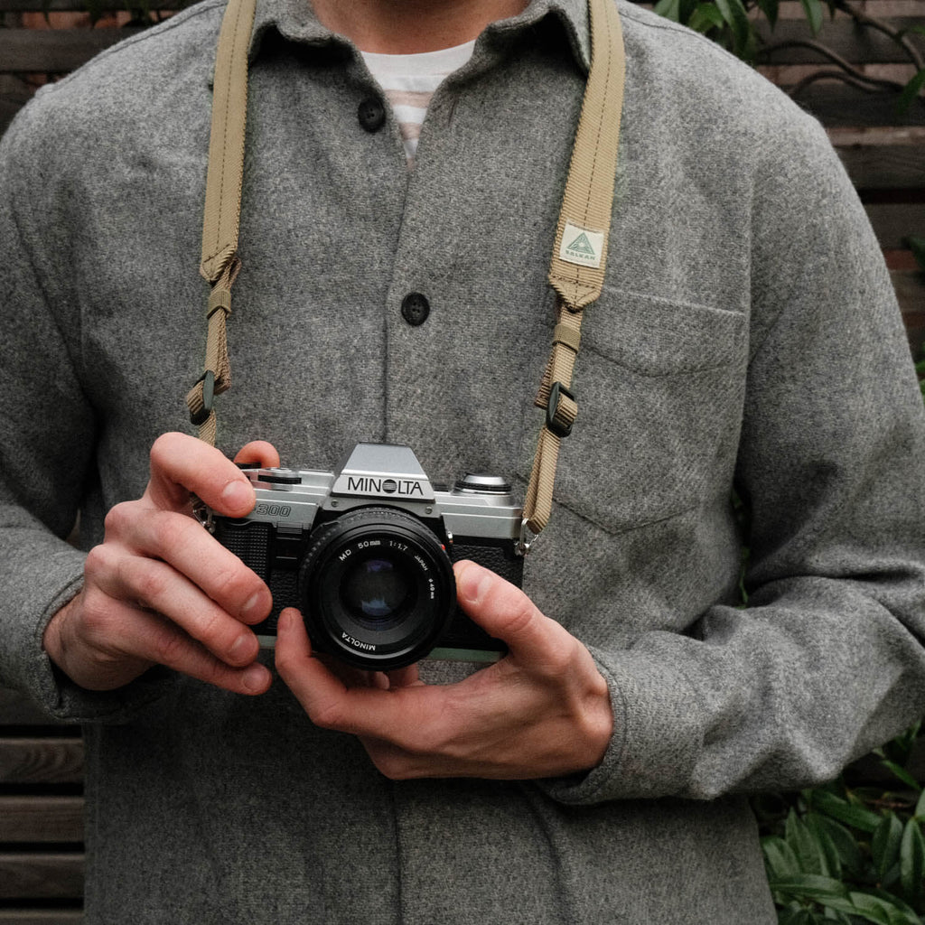 Salkan camera strap worn around the neck, holding a vintage Minolta camera outdoors